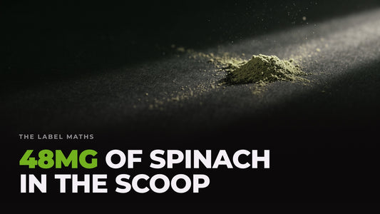A tiny pinch of green powder caught in a beam of light against near-black. Headline: 48mg of spinach in the scoop.