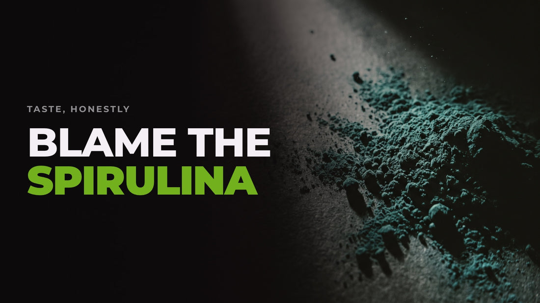 Macro shot of dark blue-green spirulina powder lit hard against a black background, captioned “Blame the spirulina”.