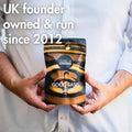 Person holding a 'Good Fats' package with text about UK founder and year of establishment. UKs highest potency Omega 3 supplement
