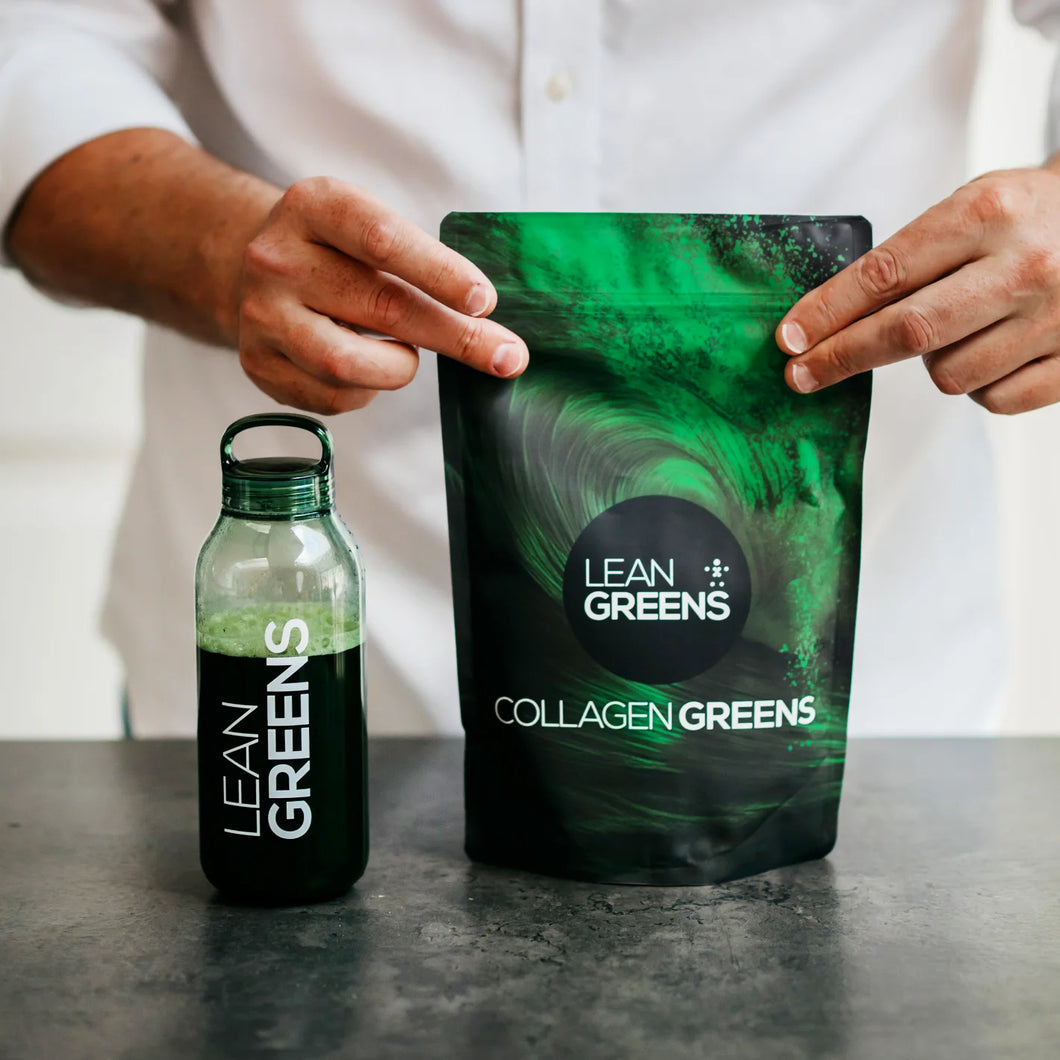 A pouch of Lean Greens Collagen Greens held open on a kitchen worktop, next to a bottle of the mixed drink